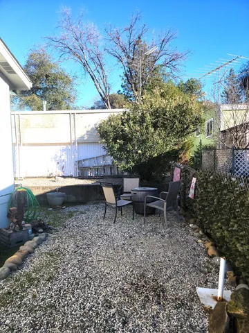a backyard of a house with table and chairs