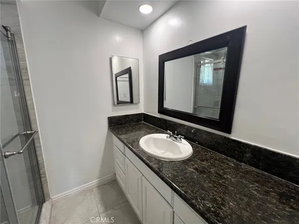 a bathroom with a granite countertop sink and a mirror