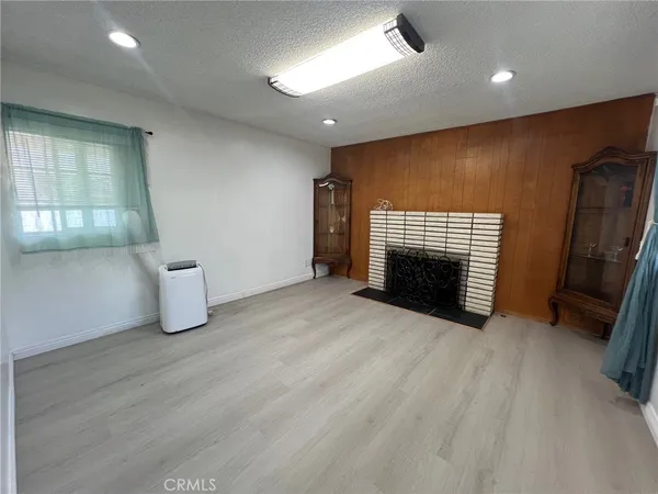 an empty room with wooden floor and fireplace