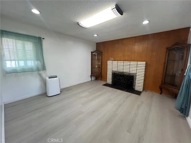 an empty room with wooden floor and fireplace