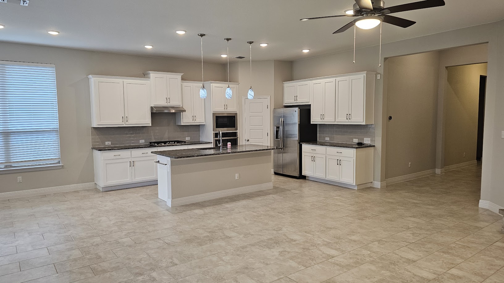 712 Muster Bend Georgetown, TX 78626 - Photo 1 of 26 Kitchen featuring pendant lighting, a center island with sink, white cabinetry, a sink, and under cabinet range hood