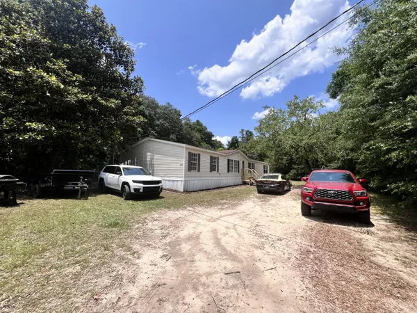 a front view of a house with cars parked
