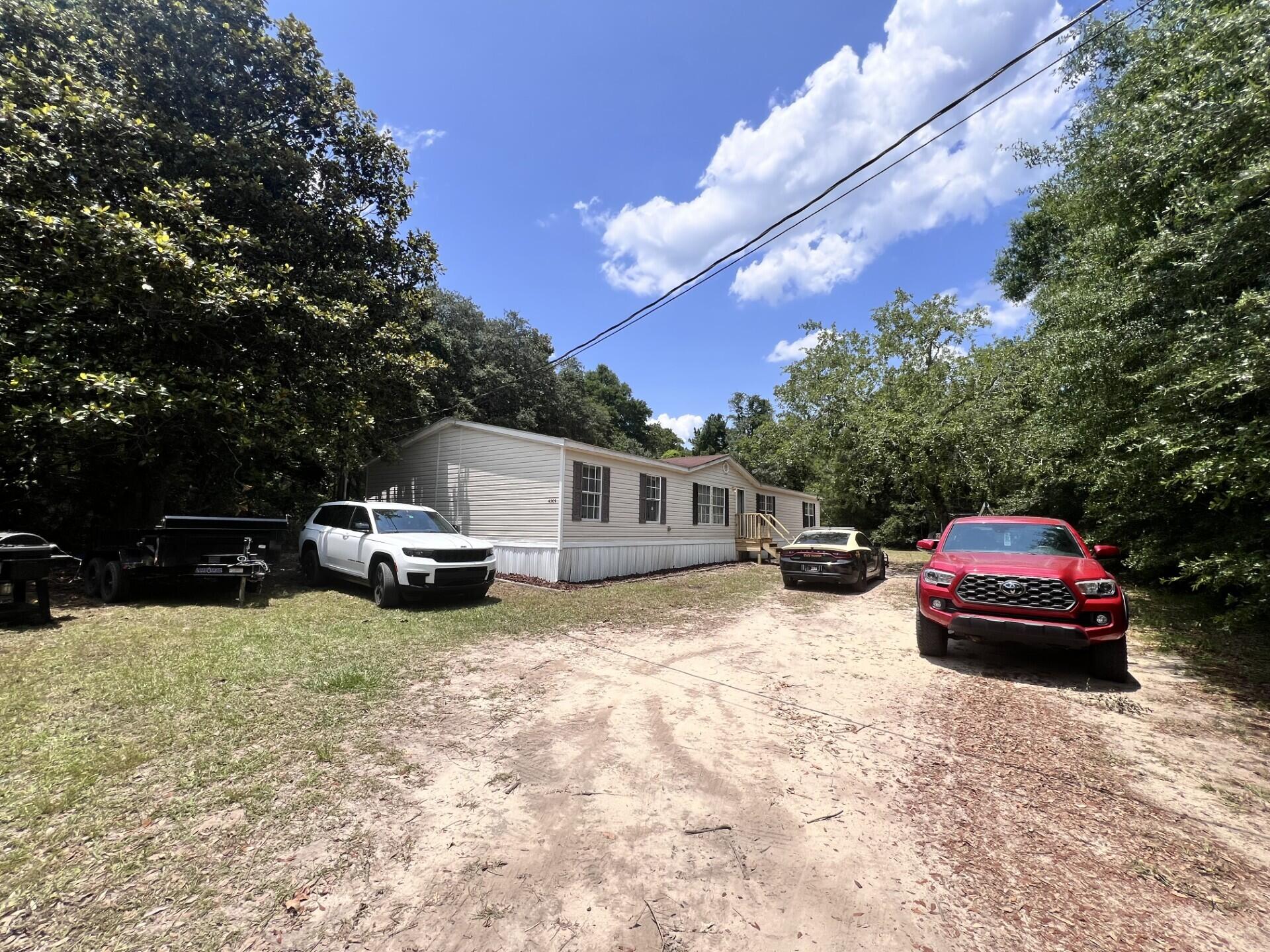 a front view of a house with cars parked