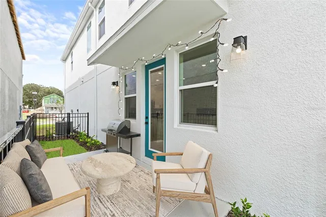 a balcony with chairs and a potted plant