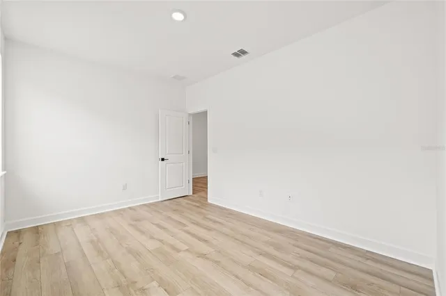 an empty room with a hardwood and closet