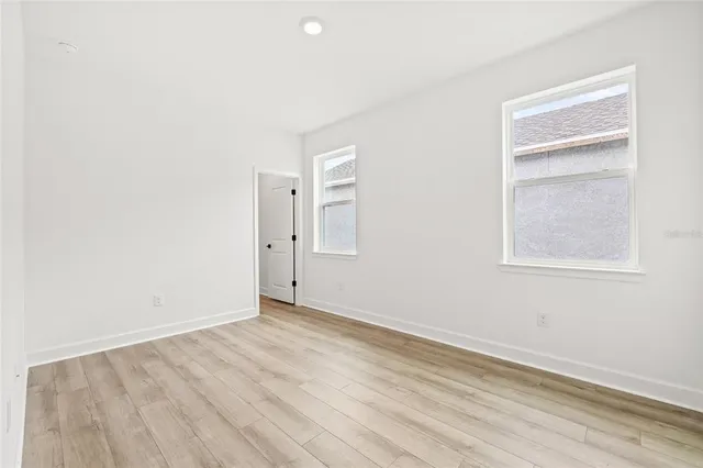 an empty room with wooden floor and entrance