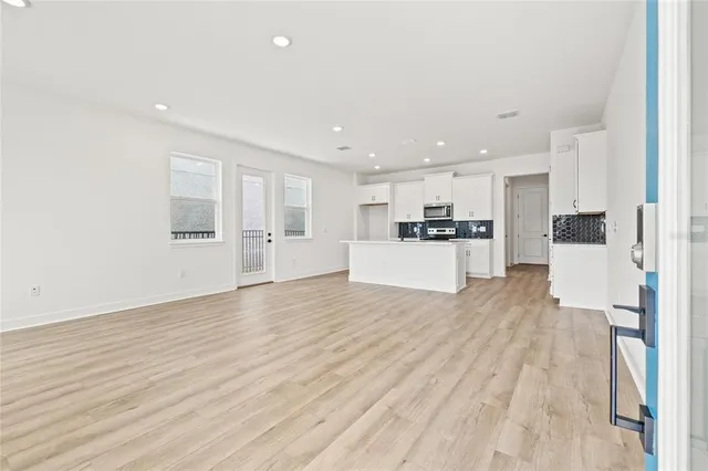 a view of kitchen with wooden floor and electronic appliances