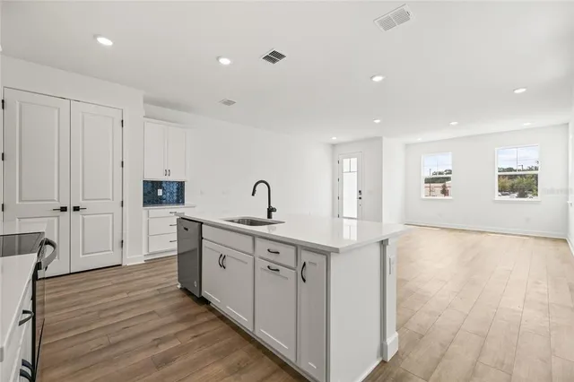 a kitchen with white cabinets and stainless steel appliances