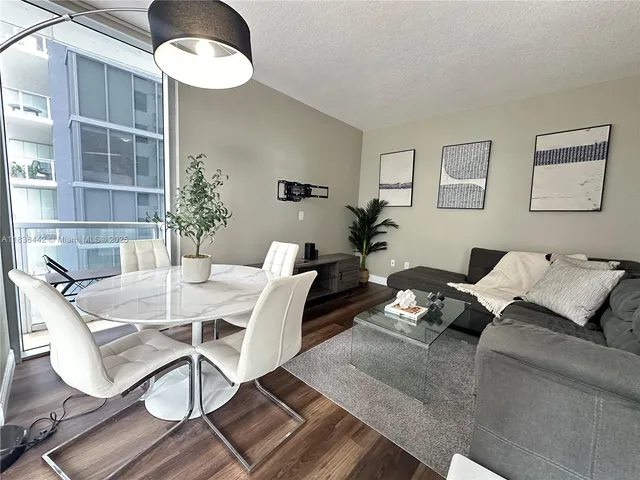 a living room with furniture flowerpot and wooden floor