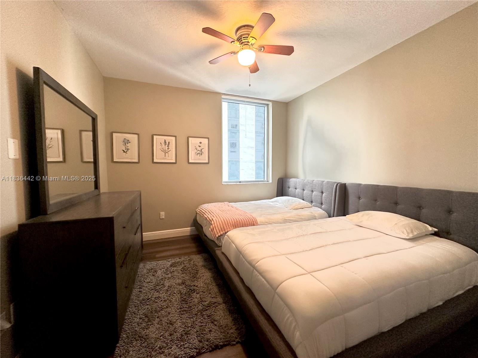 1050 Brickell Avenue, Unit 2220 Miami, FL 33131 - Photo 12 of 20 a bedroom with a bed and a chandelier