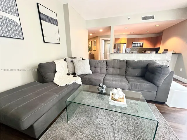 a living room with furniture and a wooden floor