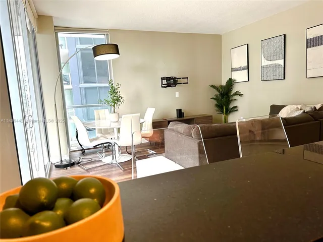 a living room with furniture a rug and white walls