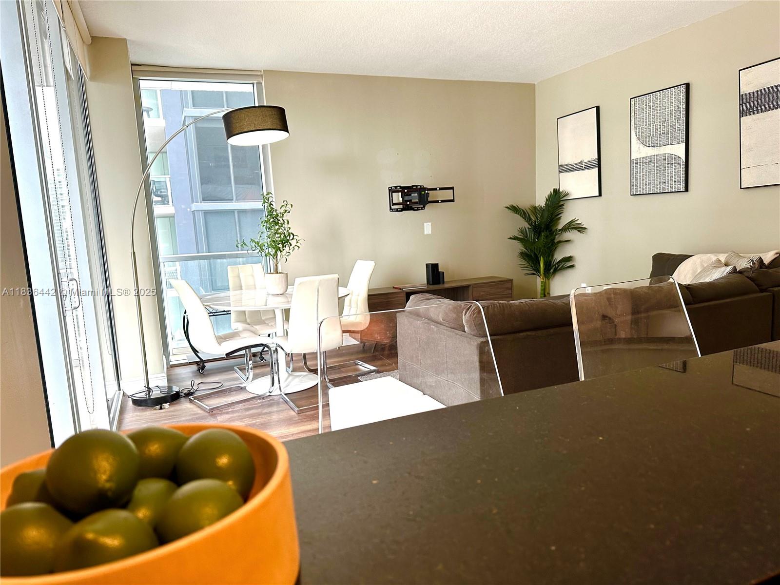 1050 Brickell Avenue, Unit 2220 Miami, FL 33131 - Photo 5 of 20 a living room with furniture a rug and white walls