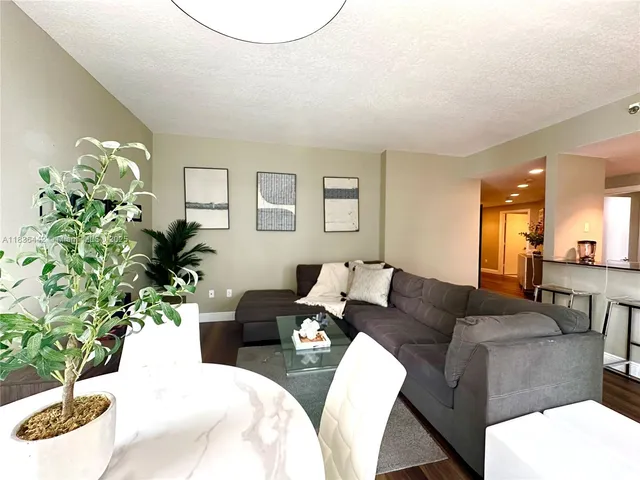 a living room with furniture potted plant and a window