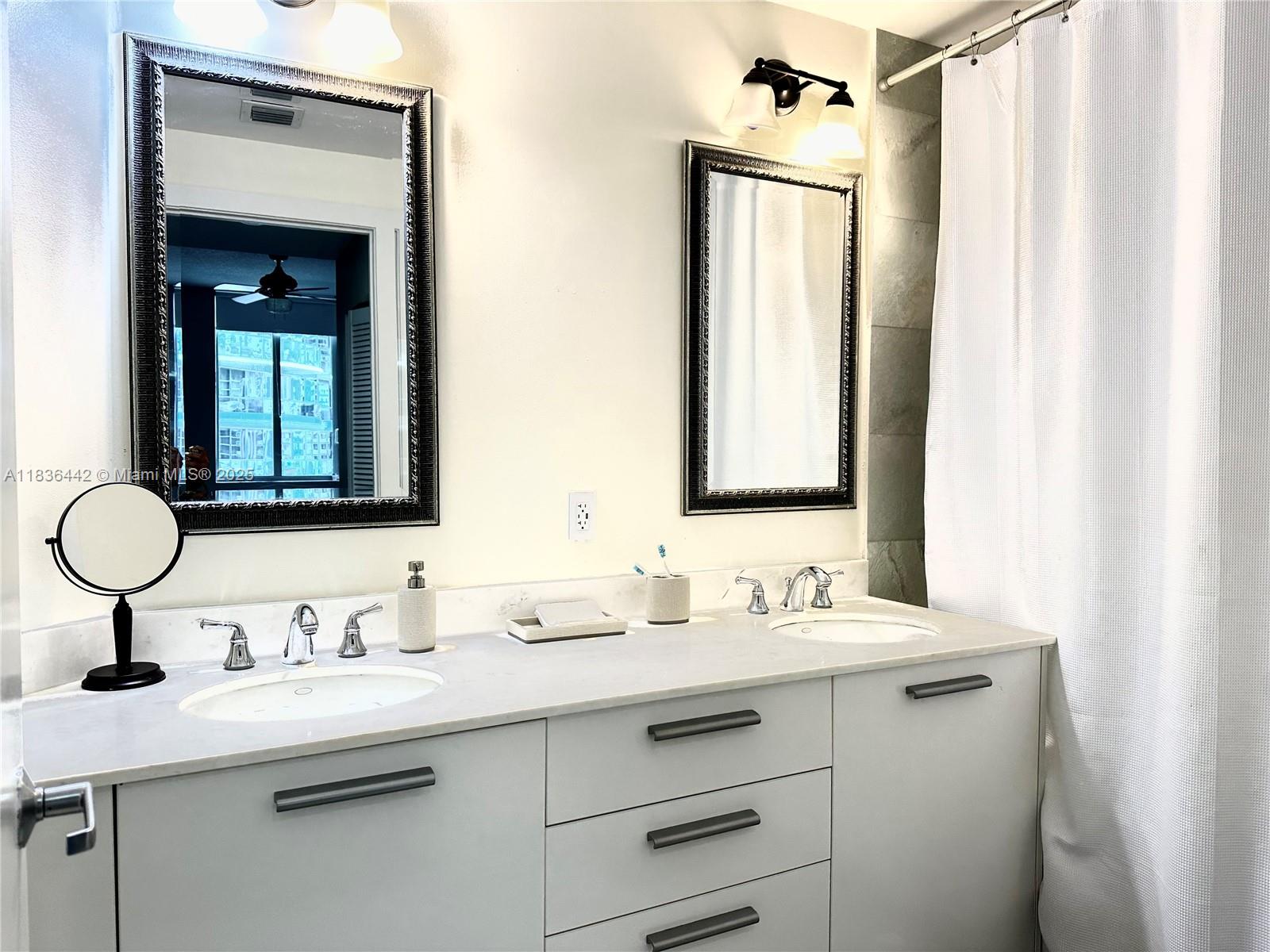 1050 Brickell Avenue, Unit 2220 Miami, FL 33131 - Photo 9 of 20 a bathroom with a double vanity sink mirror and