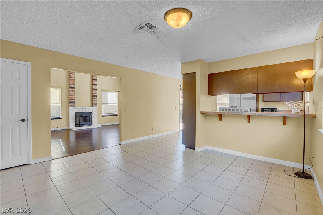 6440 Hartwood Road Las Vegas, NV 89108 - Photo 12 of 59 A well-lit interior offers a versatile layout with a cozy fireplace focal point and convenient kitchen pass-through.