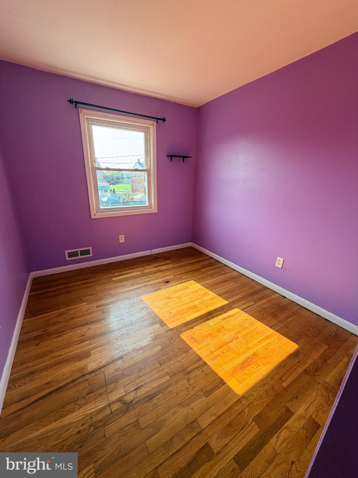 1707 Stokesley Road Baltimore, MD 21222 - Photo 13 of 18 Vibrant purple room with sunny charm.