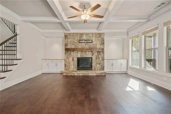 an empty room with windows and fireplace