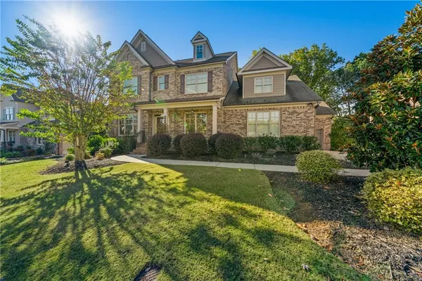 a front view of a house with yard and green space