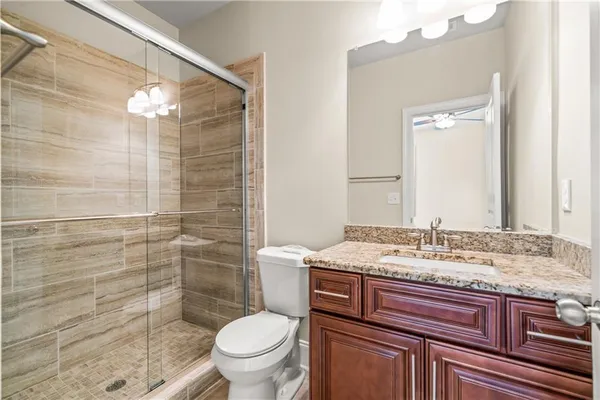 a bathroom with a granite countertop sink toilet and shower