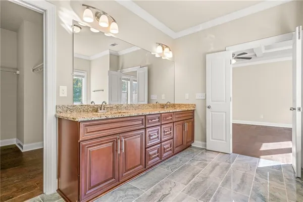 a bathroom with a granite countertop double vanity sink and a mirror