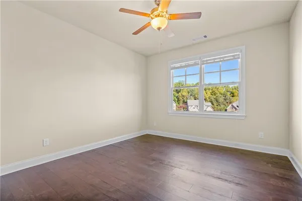 an empty room with windows and ceiling fan