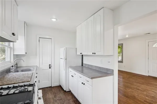 a kitchen with granite countertop a sink stove and cabinets