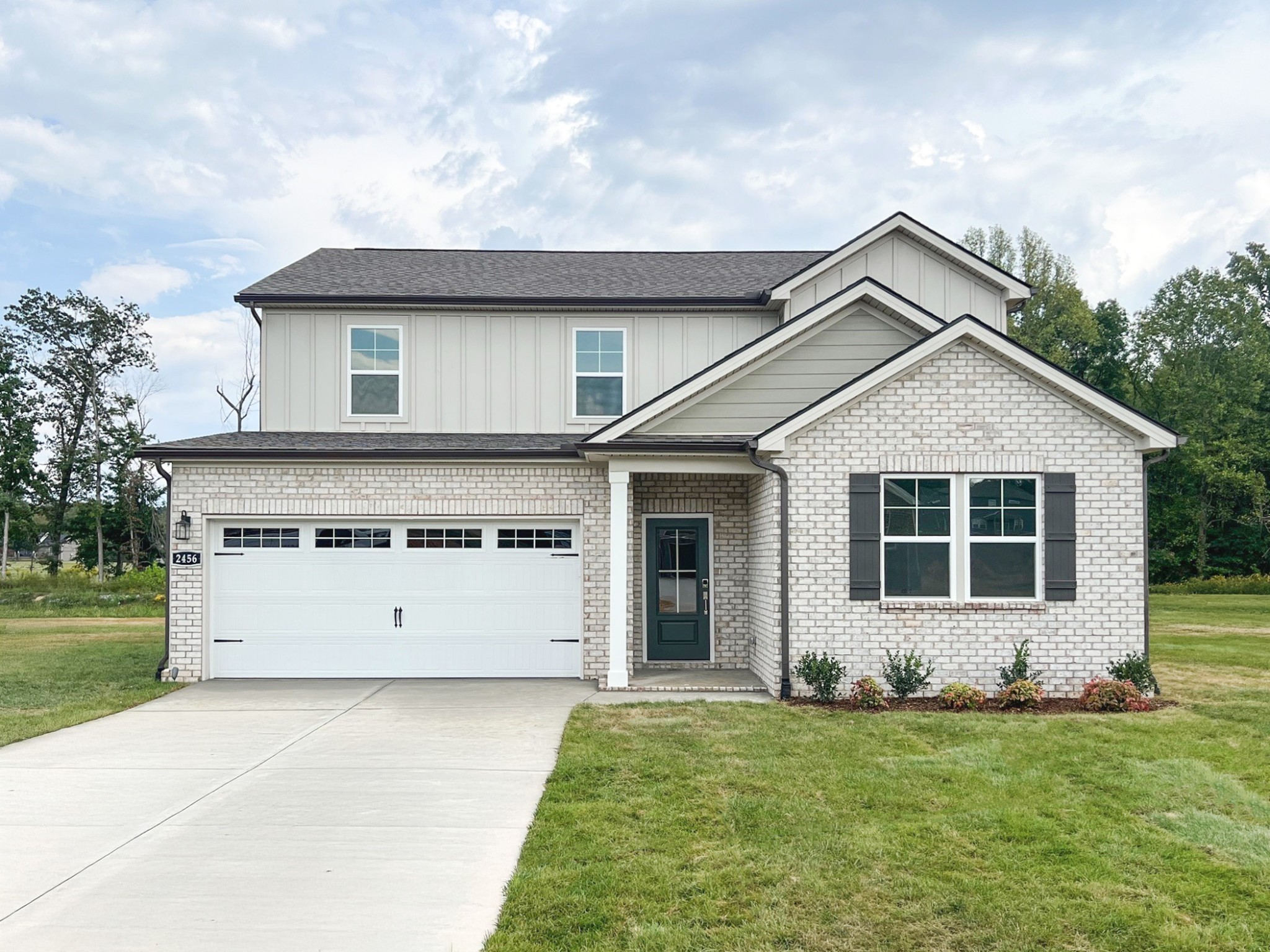 a front view of a house with a garden and yard