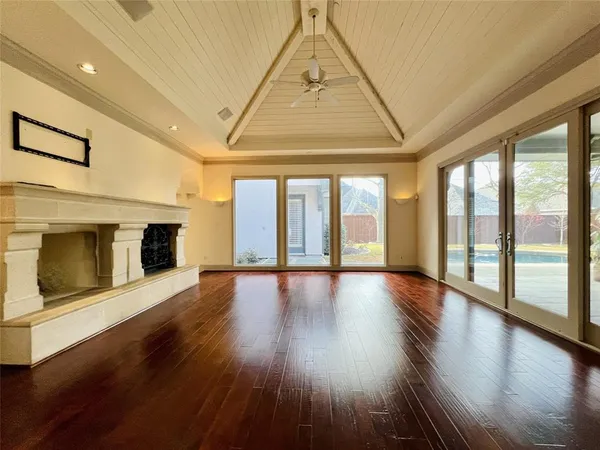 an empty room with wooden floor and fireplace