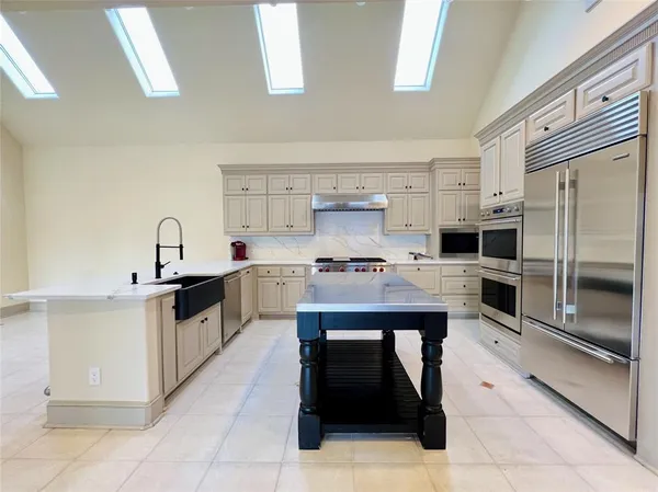 a kitchen with stainless steel appliances granite countertop a stove refrigerator and cabinets