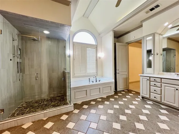 a spacious bathroom with a mirror a sink and a shower