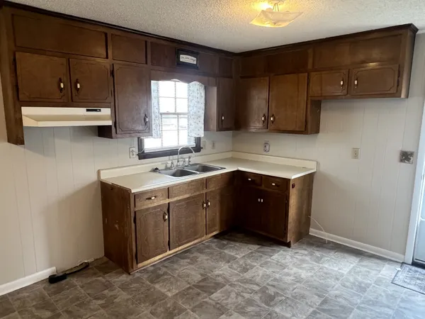 a kitchen with a sink window and cabinets