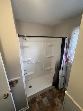 a bathroom with a glass door shower and toilet
