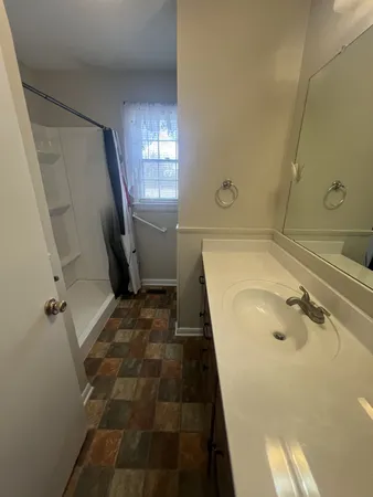 a bathroom with a tub sink and mirror