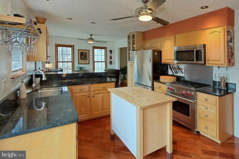 1874 Post Oak Trail Reston, VA 20191 - Photo 25 of 30 a kitchen with stainless steel appliances granite countertop a sink a stove and a refrigerator