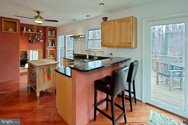 1874 Post Oak Trail Reston, VA 20191 - Photo 9 of 30 a kitchen with stainless steel appliances granite countertop a table chairs in it and wooden floors