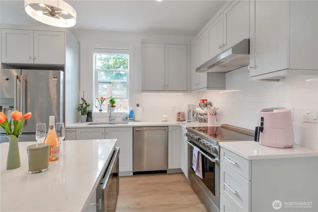a kitchen with stainless steel appliances granite countertop a sink a stove and a refrigerator