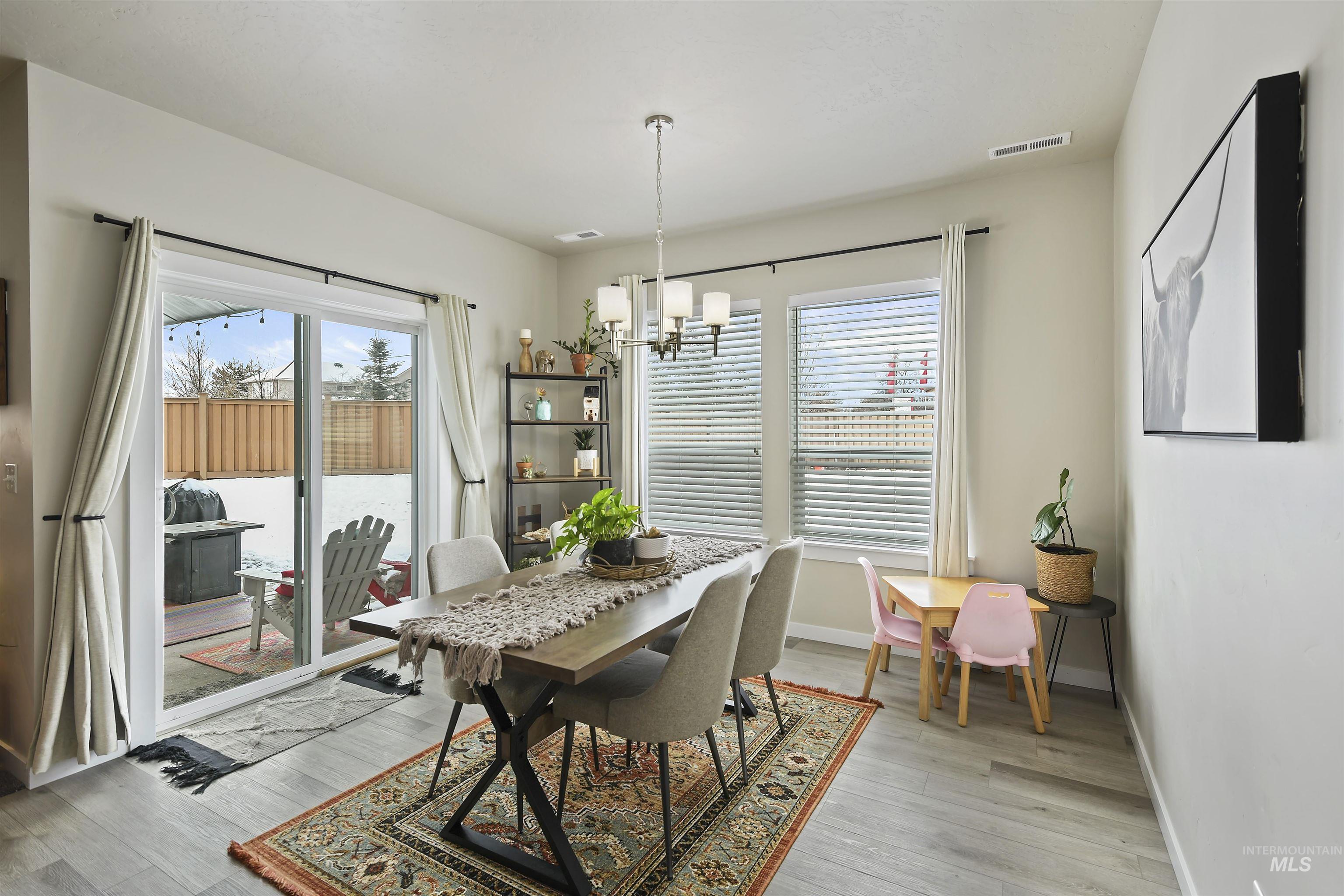 13472 Deodar Street Caldwell, ID 83607 - Photo 10 of 22 Dining room featuring a chandelier, light wood-style floors, and plenty of natural light