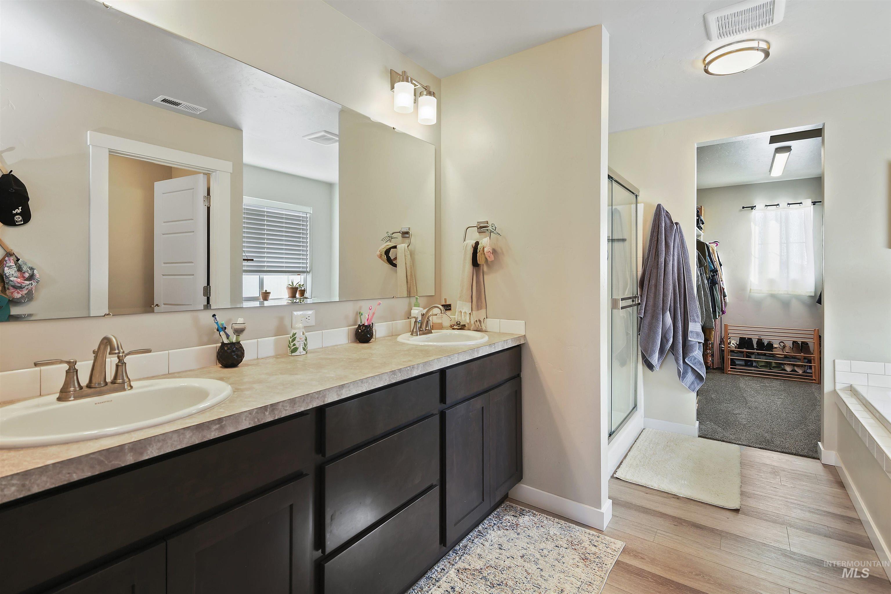 13472 Deodar Street Caldwell, ID 83607 - Photo 13 of 22 Full bathroom featuring double vanity, a stall shower, light wood-type flooring, and healthy amount of natural light