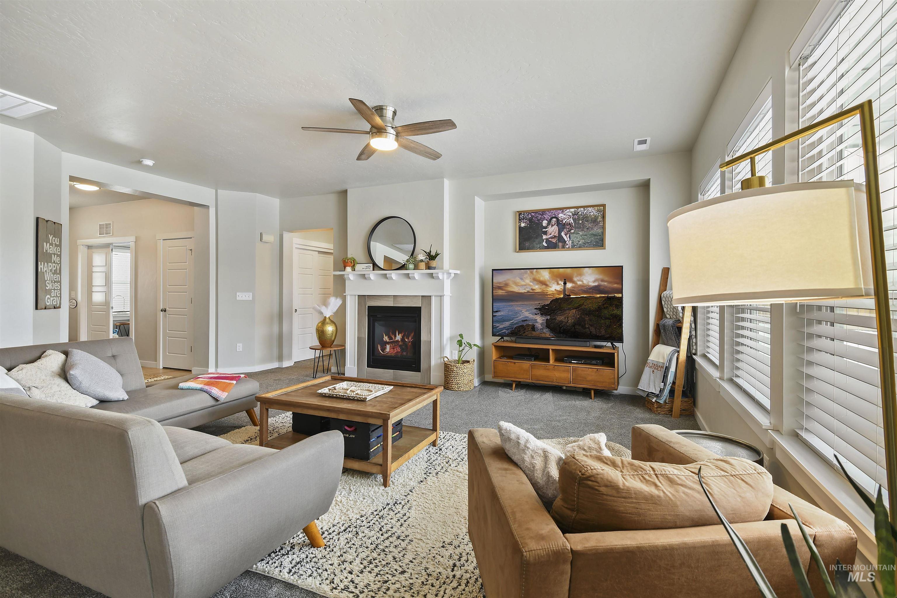 13472 Deodar Street Caldwell, ID 83607 - Photo 5 of 22 Living area with a fireplace, a ceiling fan, and carpet flooring