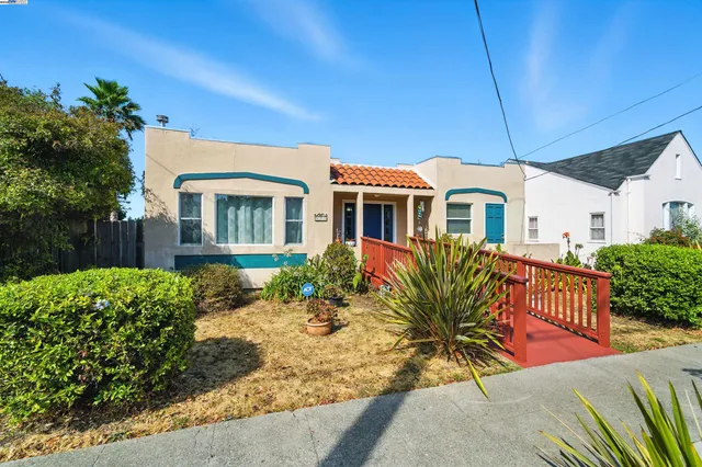 a view of a house with a small yard and potted plants