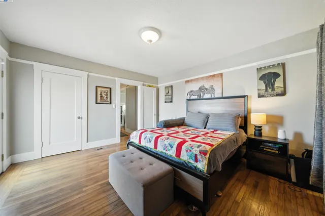 a bedroom with a bed and wooden floor