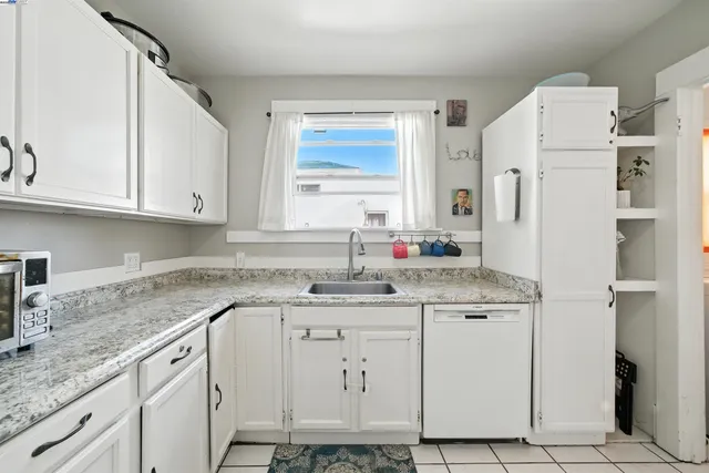 a kitchen with cabinets appliances a sink and a window