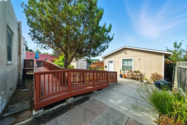 a view of backyard with deck and outdoor seating