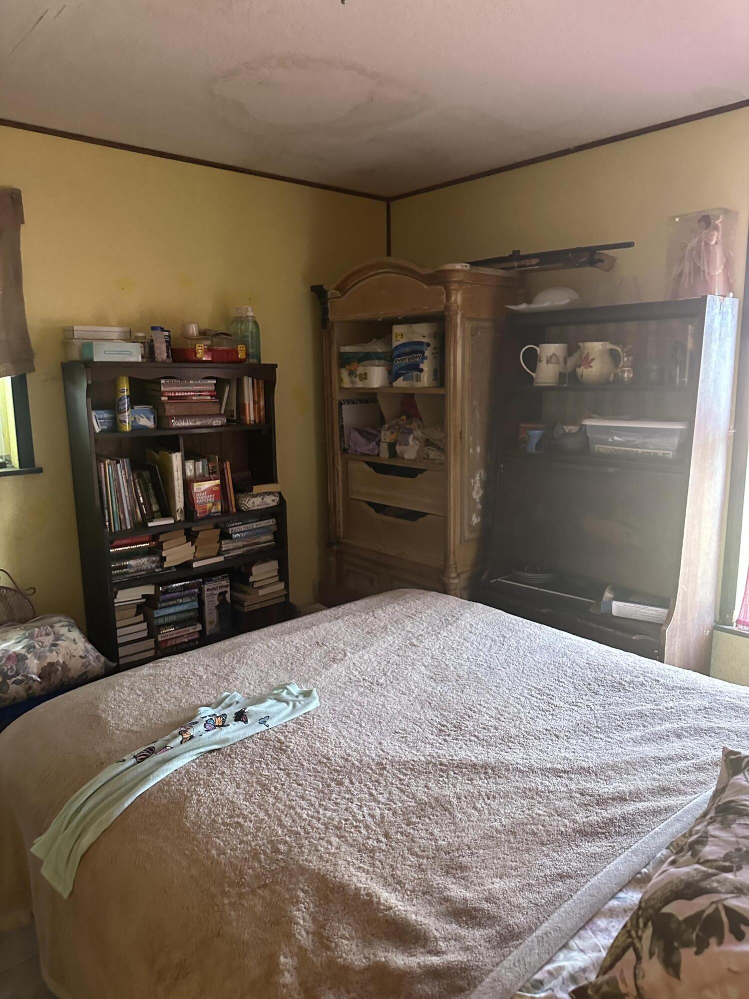 19632 Northwest 252nd Street Okeechobee, FL 34972 - Photo 6 of 11 a bed room with a bed and a television