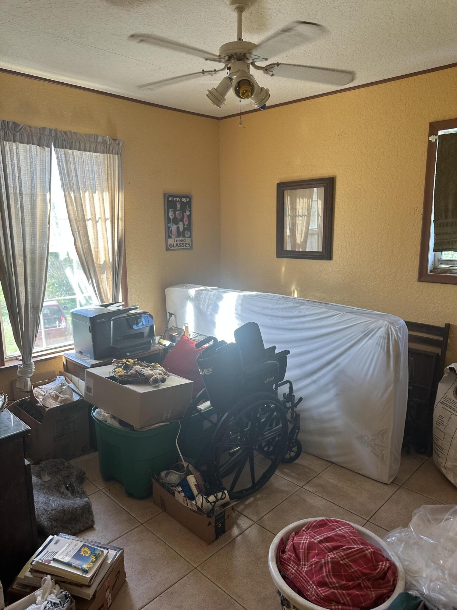 19632 Northwest 252nd Street Okeechobee, FL 34972 - Photo 9 of 11 a bed room with a bed and a chair