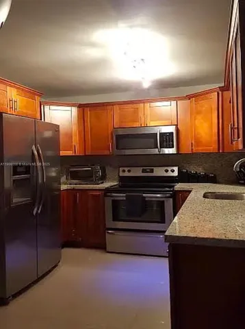 a kitchen with stainless steel appliances a stove a refrigerator and a sink