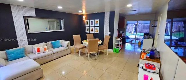 a living room with furniture and a dining table with projector kitchen