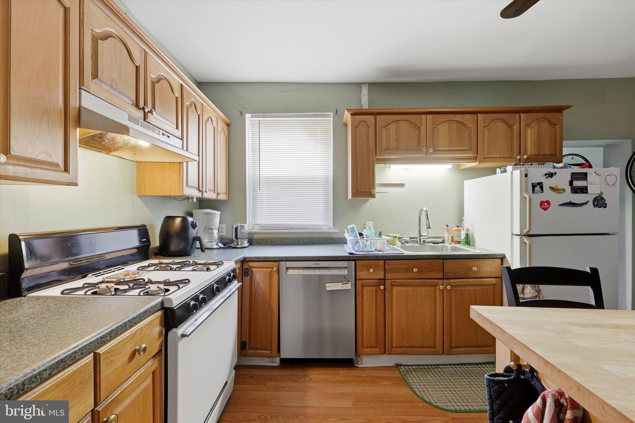 2442 East Gordon Street Philadelphia, PA 19125 - Photo 18 of 40 a kitchen with stainless steel appliances a stove a sink cabinets and a dining table