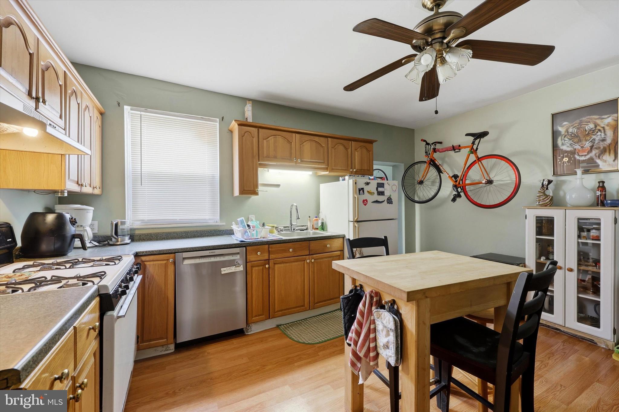 2442 East Gordon Street Philadelphia, PA 19125 - Photo 19 of 40 a kitchen with a table chairs cabinets a stove and a window